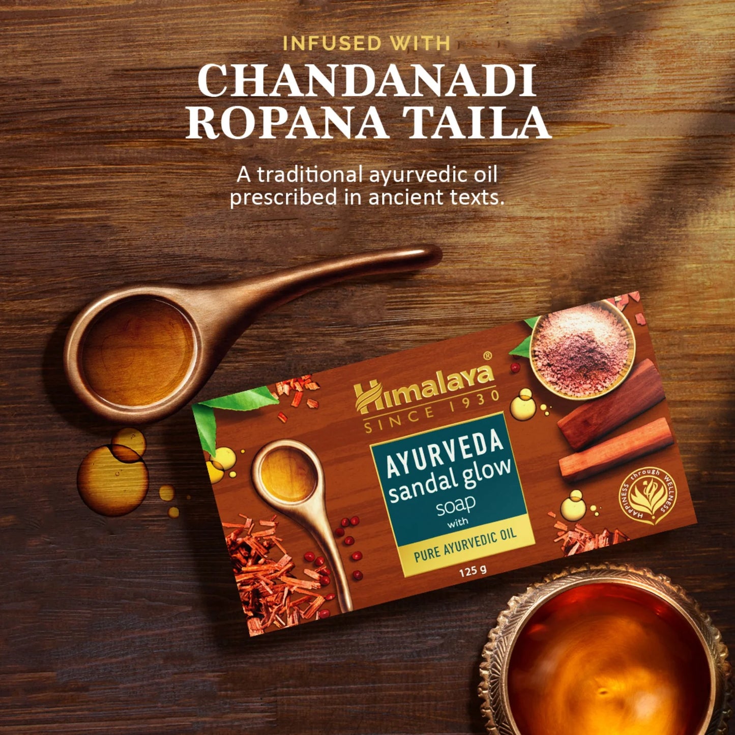 Himalaya Ayurveda Sandal Glow Soap packaging with wooden spoon and oil droplets on a wooden background