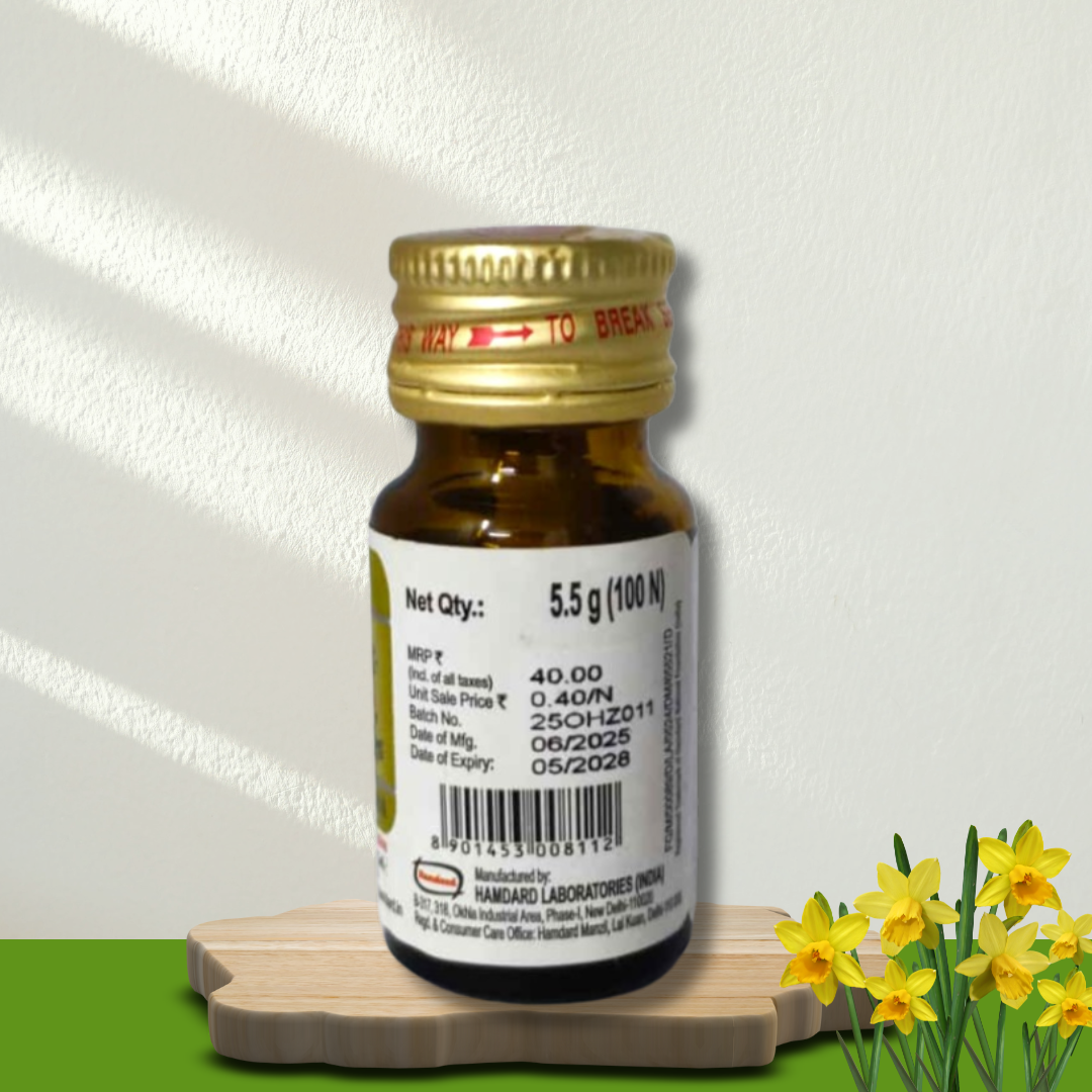 Small brown bottle with a gold cap on a wooden board with yellow flowers on a white background